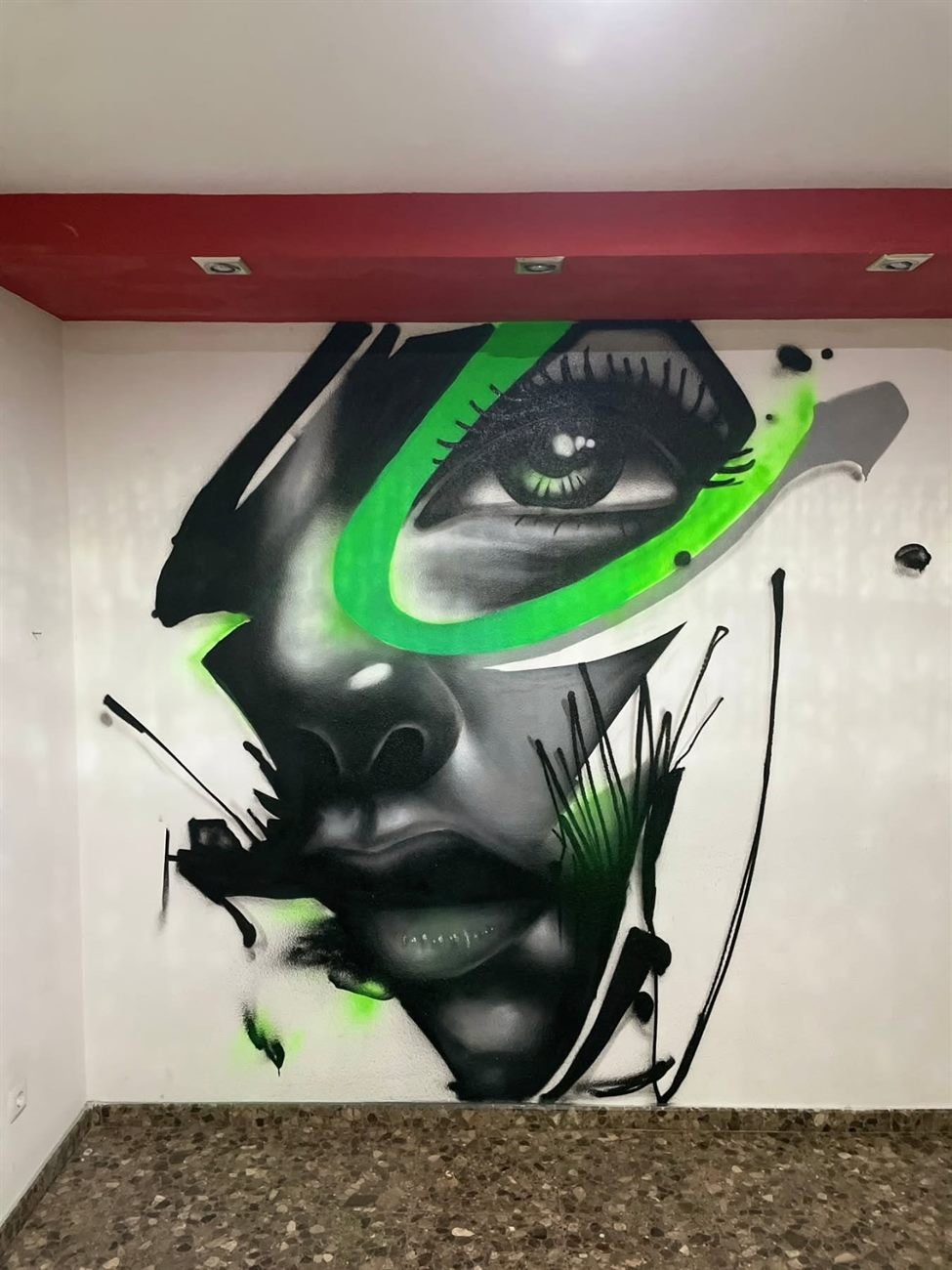 Mural realista con acentos verdes pintado a mano en Valencia